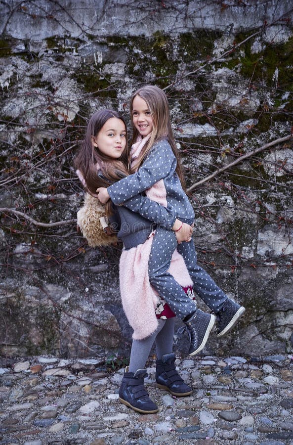 Ein Mädchen, das ihre Schwester in den Armen hält stockfoto Ein Mädchen, das ihre Schwester in den Armen hält stockfoto