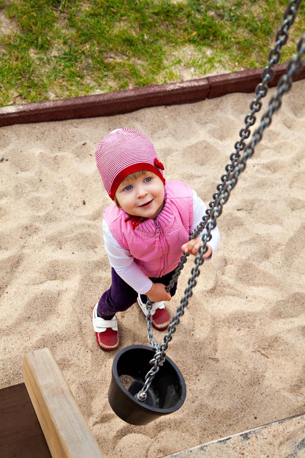 Ein Mädchen, das am Sandkasten mit Eimer spielt lizenzfreies stockfoto Ein Mädchen, das am Sandkasten mit Eimer spielt lizenzfreies stockfoto