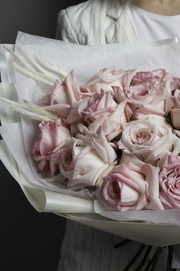 Ein Mädchen in der weißen Kleidung hält einen empfindlichen schönen Blumenstrauß von rosa Rosen, in einem lichtdurchlässigen Pake stockfotos Ein Mädchen in der weißen Kleidung hält einen empfindlichen schönen Blumenstrauß von rosa Rosen, in einem lichtdurchlässigen Pake stockfotos