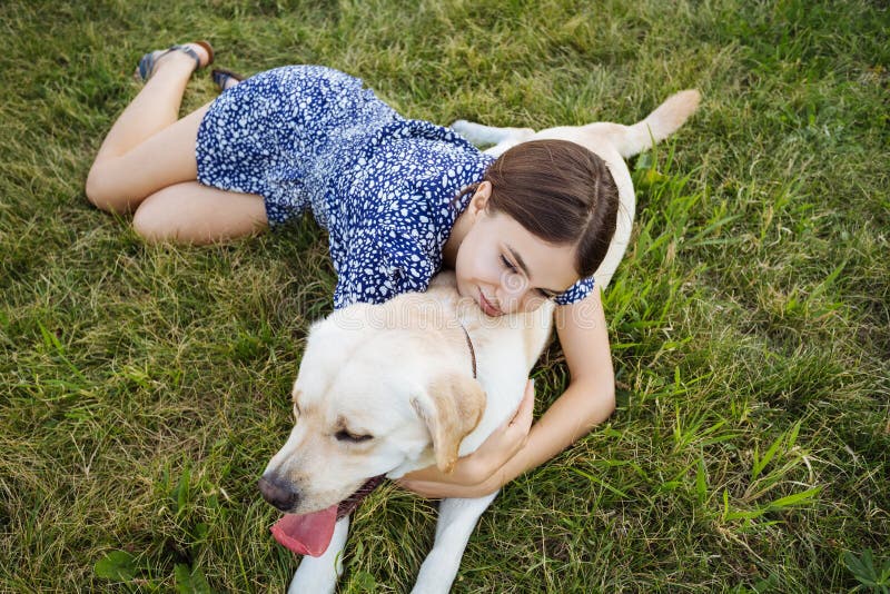 Ein Mädchen spielt mit einem Hund auf dem Gras Ausbildung des Hundes Beschneidungspfad eingeschlossen stockfotografie Ein Mädchen spielt mit einem Hund auf dem Gras Ausbildung des Hundes Beschneidungspfad eingeschlossen stockfotografie