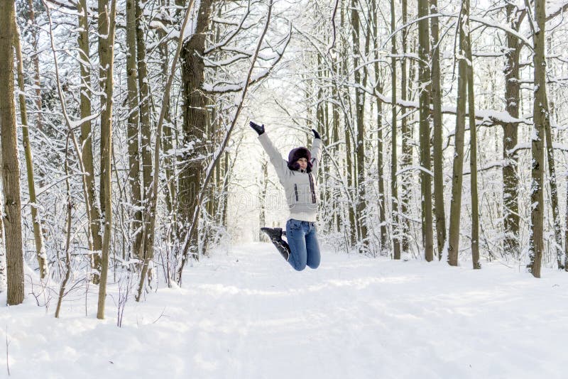 Ein Mädchen springt im Wald oben Viel Schnee stockfotografie