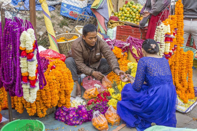 Ein Nepali Mann verkauft Blumen an eine Frau in einem blauen Kleid, Straßenhändler von hellem buntem frischem lizenzfreies stockbild Ein Nepali Mann verkauft Blumen an eine Frau in einem blauen Kleid, Straßenhändler von hellem buntem frischem lizenzfreies stockbild