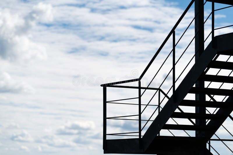 Ein Notausgang oder ein externes Treppenhaus auf einem Gebäude silhouettiert gegen einen bewölkten Himmel lizenzfreies stockbild Ein Notausgang oder ein externes Treppenhaus auf einem Gebäude silhouettiert gegen einen bewölkten Himmel lizenzfreies stockbild