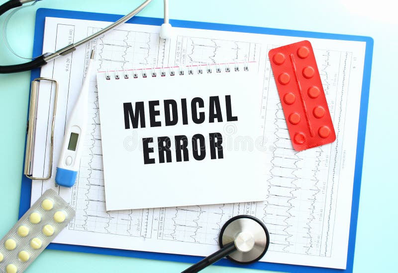 Ein Notizblock mit einem medizinischen Textfehler liegt auf einer medizinischen Zwischenablage mit einem Stethoskop und Pillen auf