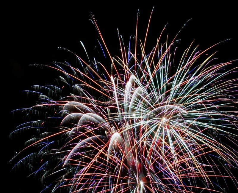 Ein nächtlicher Himmel voll der explodierenden Feuerwerke stockfotografie