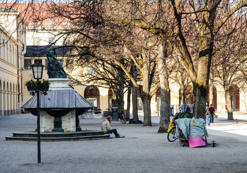 Ein obdachloser Mann sitzt durch einen verschalten Brunnen stockbilder Ein obdachloser Mann sitzt durch einen verschalten Brunnen stockbilder