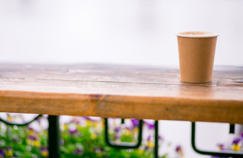 Ein Papiertasse kaffee mit Cappuccinoschaum-Kaffeekunst im Stra?enhintergrund Kraftpapierschale stockfotos Ein Papiertasse kaffee mit Cappuccinoschaum-Kaffeekunst im Stra?enhintergrund Kraftpapierschale stockfotos