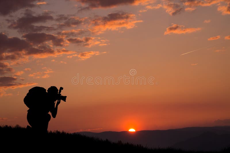 Ein Schattenbild eines Fotografen und des schönen Sonnenuntergangs und der Wolken im Hintergrund stockbilder Ein Schattenbild eines Fotografen und des schönen Sonnenuntergangs und der Wolken im Hintergrund stockbilder