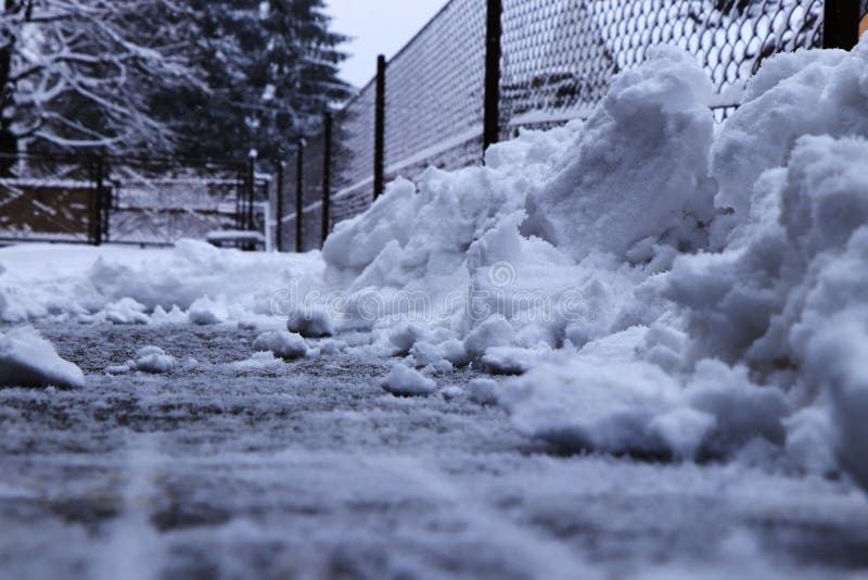 Ein Schneestapel nahe Zaun Versuchender schaufelnder Schnee von der Fahrstraße Zwanzig Zentimeter Schneebettdecke müssen gesäuber stockfoto Ein Schneestapel nahe Zaun Versuchender schaufelnder Schnee von der Fahrstraße Zwanzig Zentimeter Schneebettdecke müssen gesäuber stockfoto