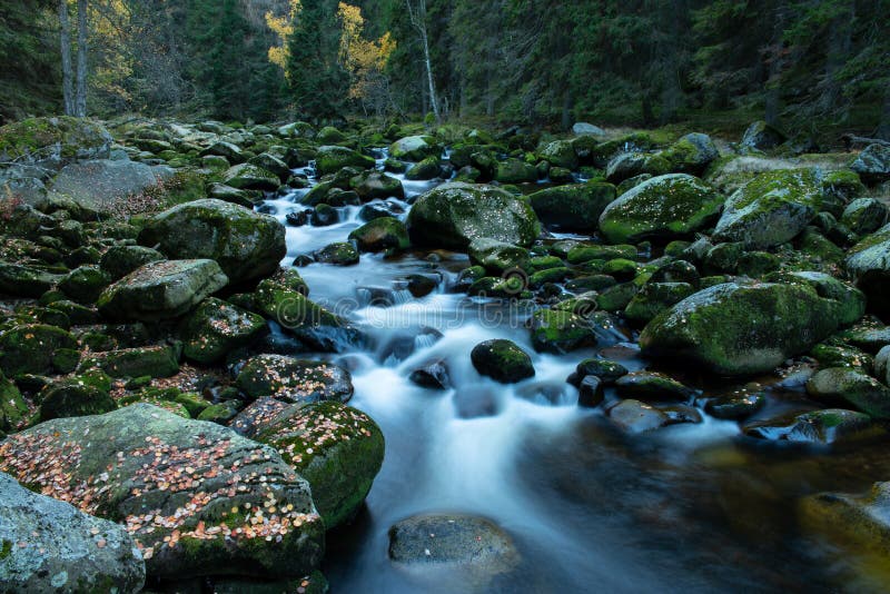 Ein Schritt gegen den unersättlichen Fluss eines wilden Wassers inmitten von Wartesteinen stockfotografie Ein Schritt gegen den unersättlichen Fluss eines wilden Wassers inmitten von Wartesteinen stockfotografie