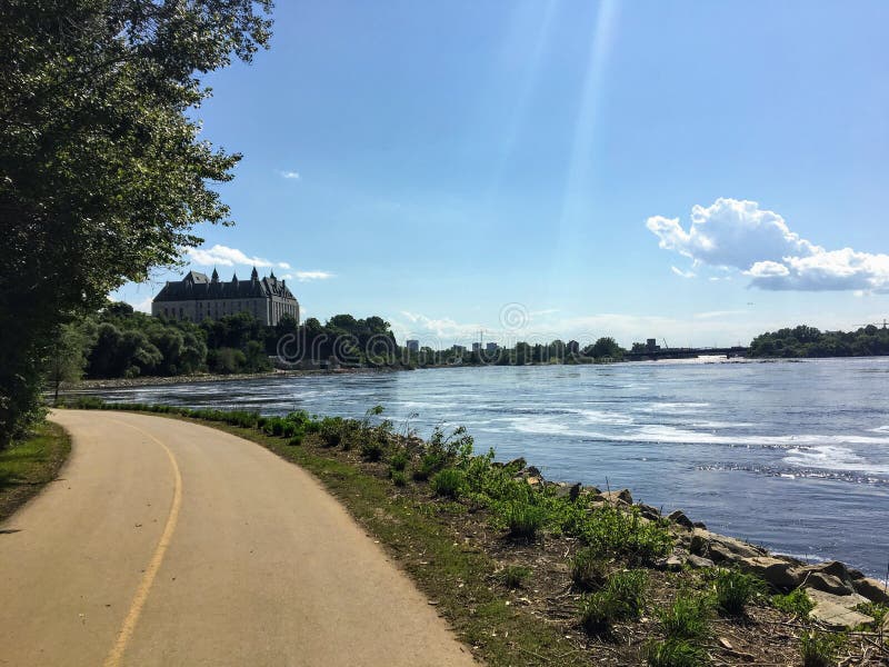 Ein schönes Fahrrad und ein Gehweg entlang dem Ottawa-Fluss an einem sonnigen Sommertag mit blauem Himmel Das Oberste Gericht von stockbilder Ein schönes Fahrrad und ein Gehweg entlang dem Ottawa-Fluss an einem sonnigen Sommertag mit blauem Himmel Das Oberste Gericht von stockbilder