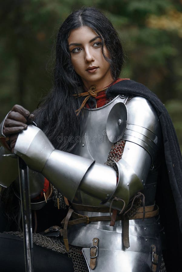 Ein schönes Kriegersmädchen mit einem Klinge tragenden chainmail und Rüstung in einem mysteriösen Wald stockbild Ein schönes Kriegersmädchen mit einem Klinge tragenden chainmail und Rüstung in einem mysteriösen Wald stockbild