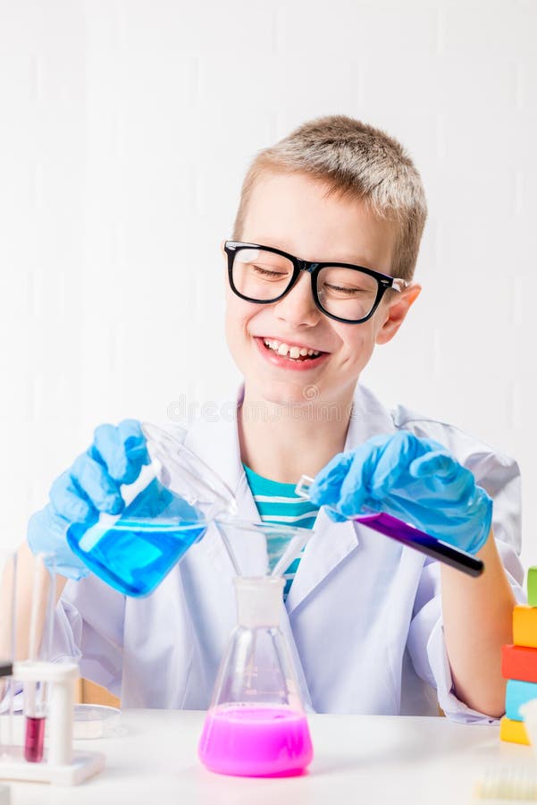 Ein Schüler studiert mehrfarbige Substanzen in Reagenzgläsern führt Versuche ein Porträt auf einem weißen Hintergrund durch. Konze stockbild
