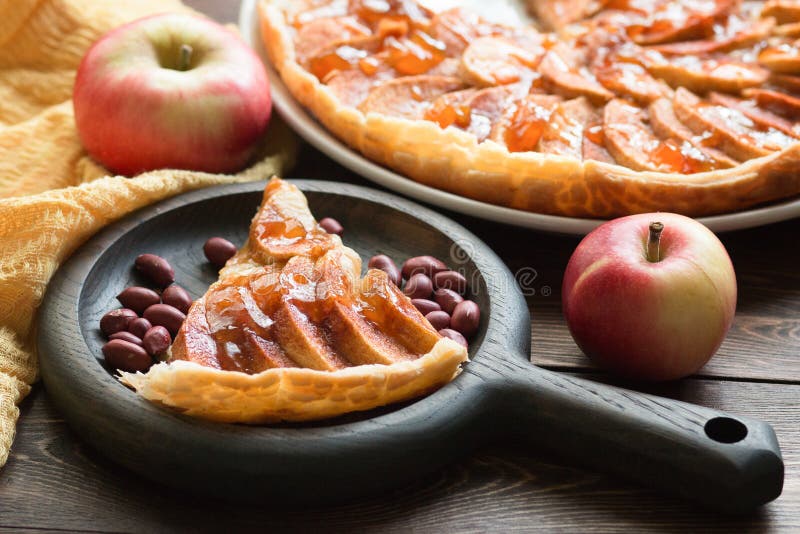 Ein Stück Apfelkuchen mit gerösteten Erdnüssen, frischem Apfel und Karamellsauce auf einem Teller Vorderansicht Backkonzept im Herbst
