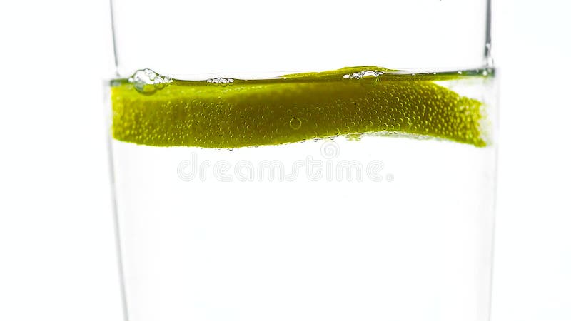 Ein Stück Zitronenfällen in ein Glas Wasser. Zeitlupe.