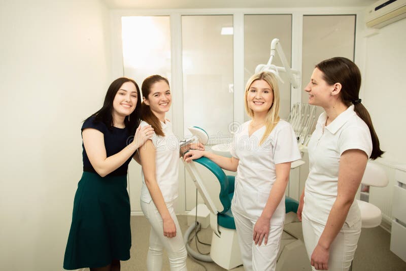 Ein Team von Fachleuten in einer zahnmedizinischen Klinik, werfend nahe der Ausr?stung auf lizenzfreie stockbilder Ein Team von Fachleuten in einer zahnmedizinischen Klinik, werfend nahe der Ausr?stung auf lizenzfreie stockbilder