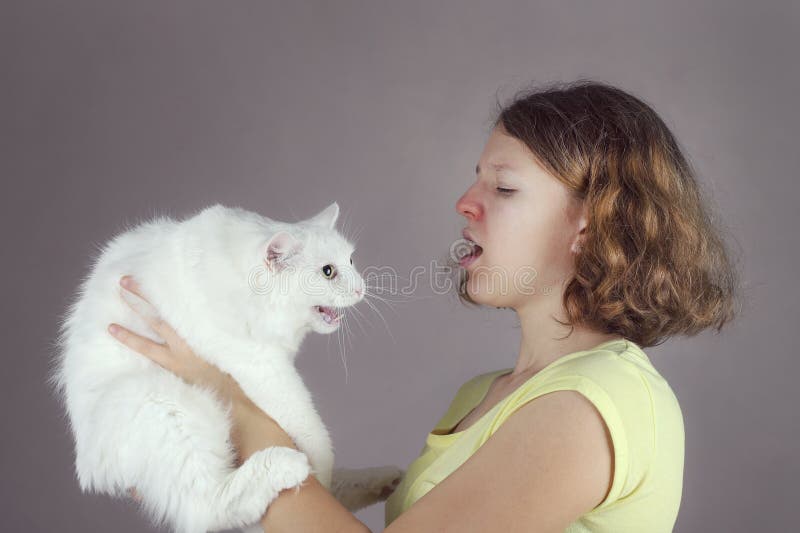 Ein teenaged allergisches Mädchen hält eine Angorakatze lizenzfreies stockfoto Ein teenaged allergisches Mädchen hält eine Angorakatze lizenzfreies stockfoto