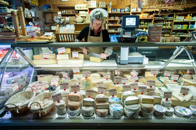Ein Verkäufer schneidet Käse in einem Einheimischen, das Milchprodukte in Italien kaufen stockfotos Ein Verkäufer schneidet Käse in einem Einheimischen, das Milchprodukte in Italien kaufen stockfotos