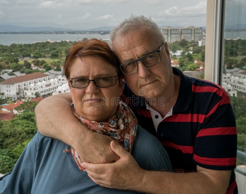 Ein älteres Paar in den Umarmungen steht auf dem Balkon ihres Hauses Familienidylle, Liebe nach Jahren lizenzfreies stockbild Ein älteres Paar in den Umarmungen steht auf dem Balkon ihres Hauses Familienidylle, Liebe nach Jahren lizenzfreies stockbild