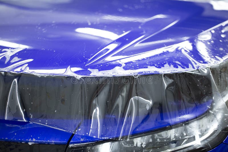 Einbau einer Schutzfolie für Autoanstriche, die Arbeiter installieren eine Schutzfolie auf dem Auto lizenzfreies stockbild