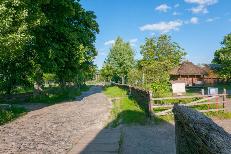 Eine alte ländliche Straße mit einer Straße gepflastert mit Kopfsteinen mit den Holzhäusern, die in den Höfen eingezäunt mit a st stockfotografie Eine alte ländliche Straße mit einer Straße gepflastert mit Kopfsteinen mit den Holzhäusern, die in den Höfen eingezäunt mit a st stockfotografie