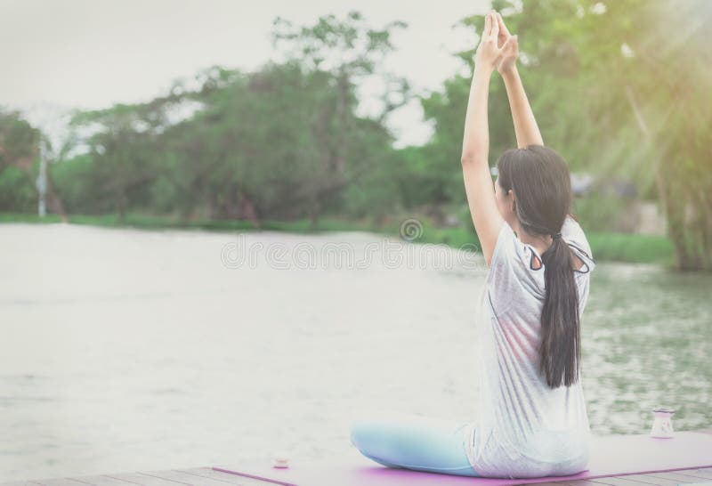 Eine Asiatin meditiert und Yoga in der Ufergegend auf einem hölzernen stockfoto Eine Asiatin meditiert und Yoga in der Ufergegend auf einem hölzernen stockfoto