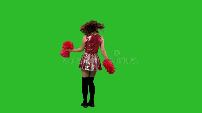 Eine charmante cheerleader tanzt einen fröhlichen tanz bewegt ihre hüften kräftig kreisen blasen ein kuss. Tanzen stock footage