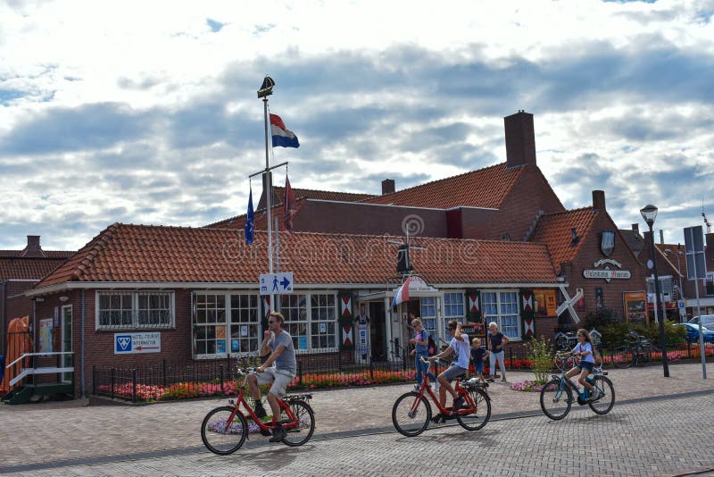 Eine Familie fährt gerne mit dem Fahrrad, vorbei am Volendam Museum lizenzfreie stockbilder Eine Familie fährt gerne mit dem Fahrrad, vorbei am Volendam Museum lizenzfreie stockbilder