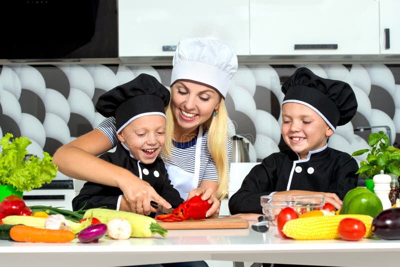 Eine Familie von Köchen Gesundes Essen Mutter und Kinder bereitet Gemüsesalat in der Küche zu stockbild Eine Familie von Köchen Gesundes Essen Mutter und Kinder bereitet Gemüsesalat in der Küche zu stockbild
