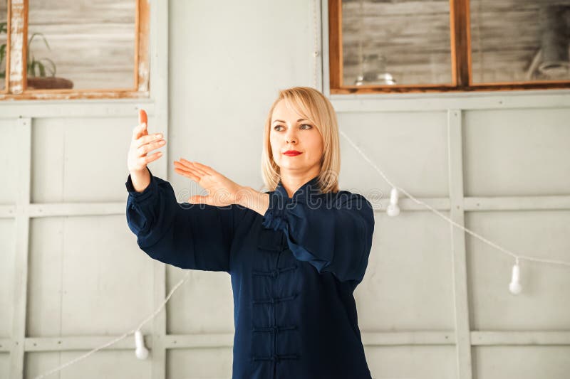 Eine Frau in einem blauen Kimono nimmt an chinesischer Kampfkunst Tai Chi-Nahaufnahme und Kopienraum teil stockbild Eine Frau in einem blauen Kimono nimmt an chinesischer Kampfkunst Tai Chi-Nahaufnahme und Kopienraum teil stockbild