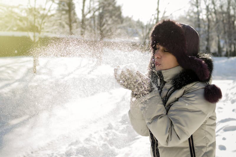 Eine Frau hält eine Handvoll Schnee in ihren Händen und brennt auf ihr durch lizenzfreie stockbilder