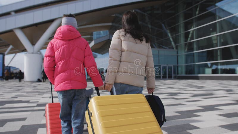 Eine Frau und ihre beiden Töchter gehen während der Coronavirus-Pandemie nach draußen zum Flughafen-Terminal.
