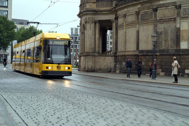 Eine gelbe Straßenbahn, die durch das Zentrum der Dresdner Saxonie fährt
