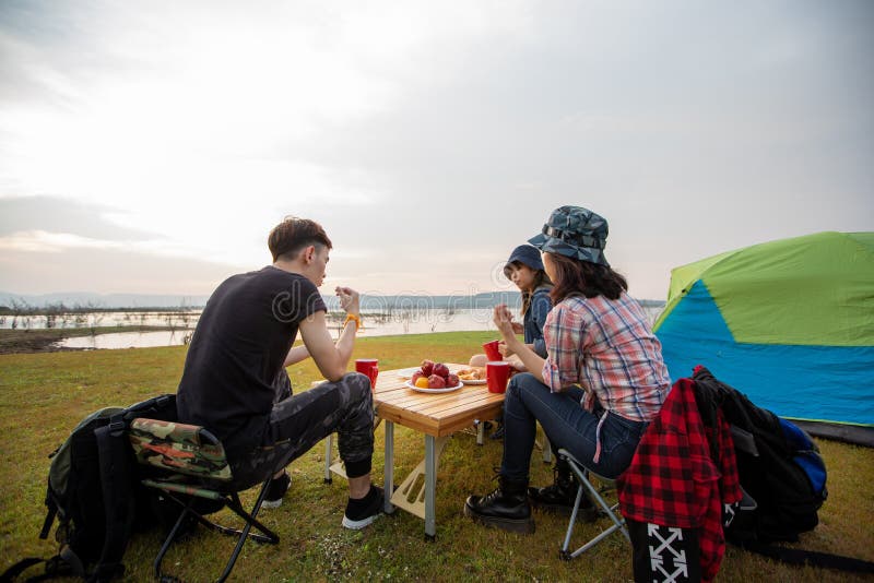 Eine Gruppe asiatischer Freunde, die Kaffee trinken und Zeit damit verbringen, in den Sommerferien ein Picknick zu machen, sie sin lizenzfreies stockbild