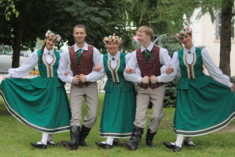 A group of young people, the Latvian folk costumes in the Park are demonstrating the dance moves. A group of young people, the Latvian folk costumes in the Park are demonstrating the dance moves