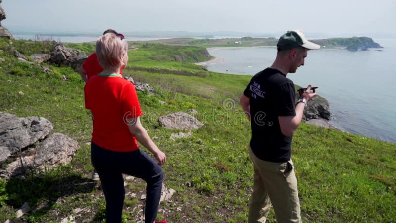 Eine Gruppe von Touristen wandert auf einem felsigen Hügel und genießt eine schöne Aussicht