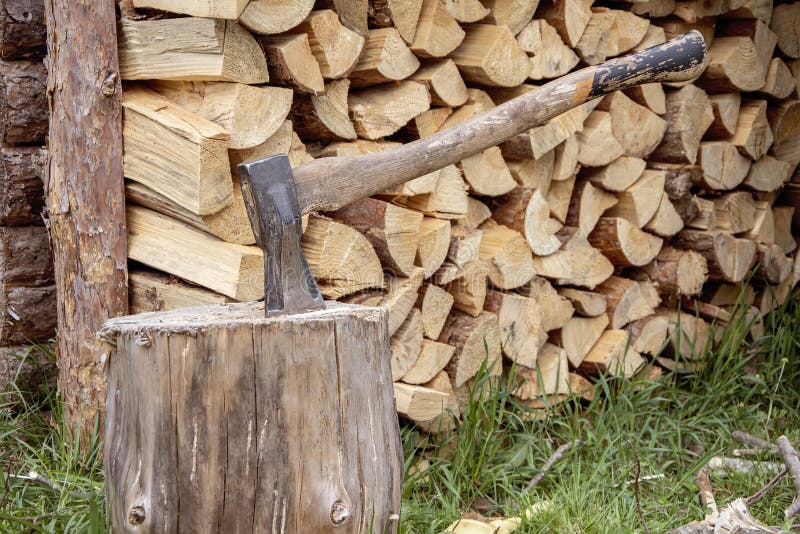 Eine Holzfällermetallaxt mit einem Holzgriff wird in einem Protokoll für das Spitzhacken von Holz vor dem Hintergrund eines getren