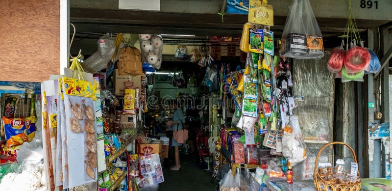 Eine junge Frau, die einige Konsumgüter im alten Lebensmittelhändler ` s Straßenshop kauft stockbilder Eine junge Frau, die einige Konsumgüter im alten Lebensmittelhändler ` s Straßenshop kauft stockbilder
