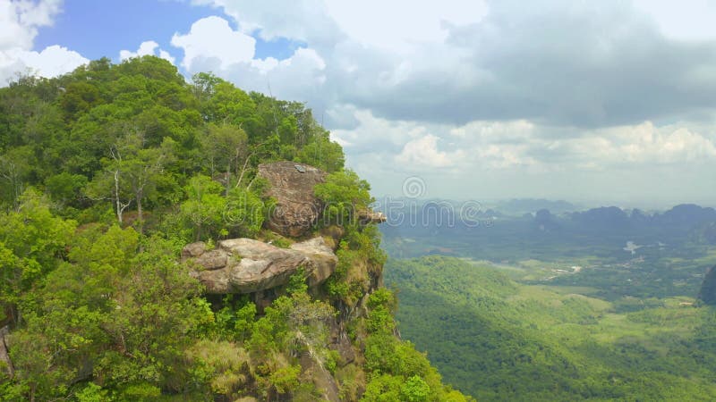 Eine junge Frau sitzt am Kliff über der Ebene an Wolken. Drachen stürzen Khao ngon nak auf krabi stock video