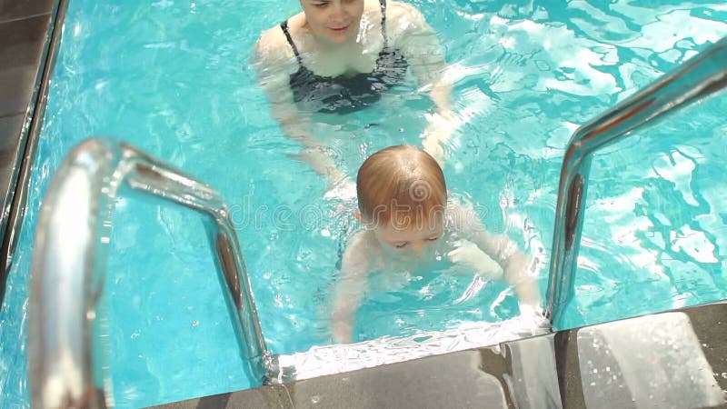Eine junge Frau unterrichtet ein Kleinkind, in das Wasser zu tauchen Langsame Bewegung