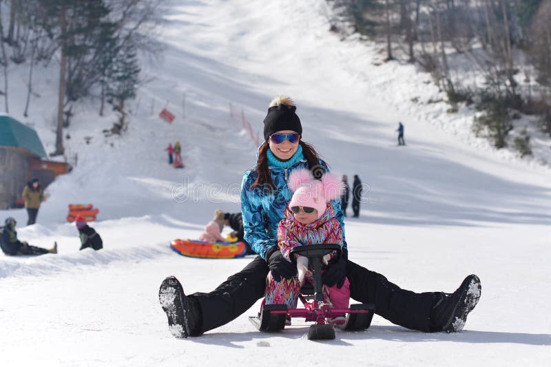 Eine junge Mutter reist in die Berge mit ihrer wenigen Tochter auf einem sonnigen Winter lizenzfreie stockfotos Eine junge Mutter reist in die Berge mit ihrer wenigen Tochter auf einem sonnigen Winter lizenzfreie stockfotos