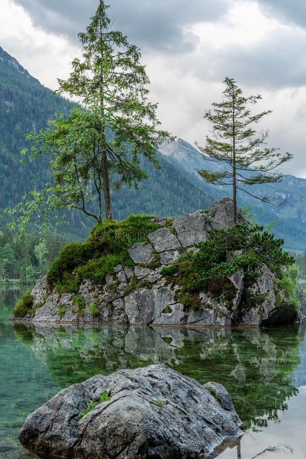 Eine kleine Insel im Bergsee überwuchert stockfoto Eine kleine Insel im Bergsee überwuchert stockfoto