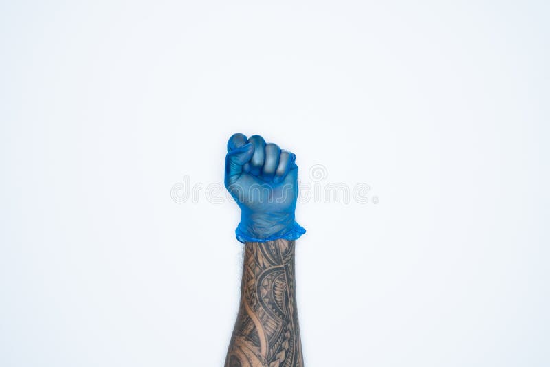 Eine Mannhand und -gesten im blauen Gummihandschuh zeigt das Faustkotzeichen, das auf weißem Hintergrund befindet lizenzfreies stockbild