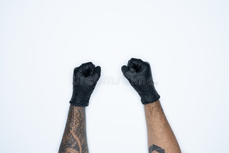 Eine Mannhand und -gesten im Schwarzen Gummihandschuh zeigt das Faustkotzeichen, das auf weißem Hintergrund befindet stockfotografie