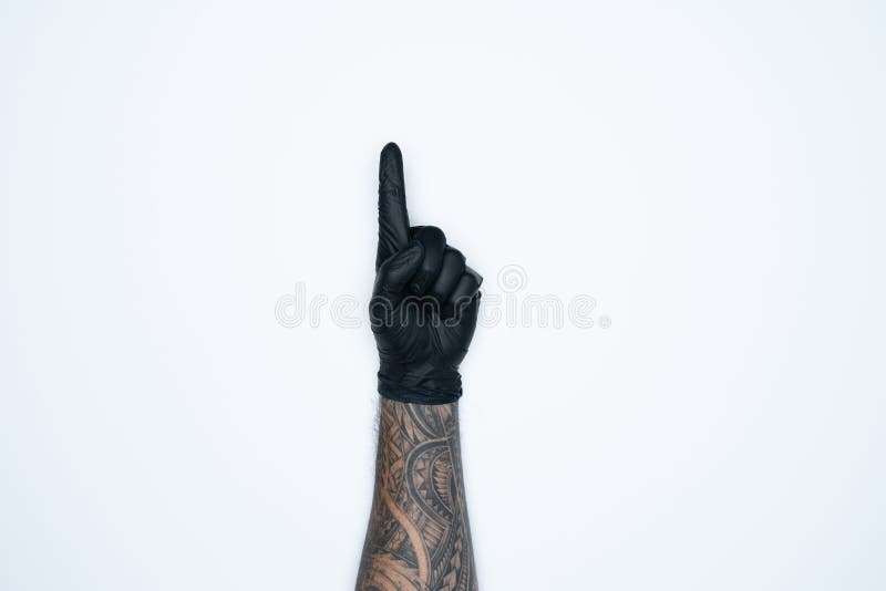 Eine Mannhand und -gesten im Schwarzen Gummihandschuh zeigt ein Zeichen, das auf weißem Hintergrund befindet stockfotografie