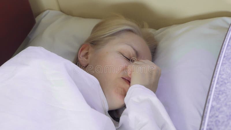 Eine müde Frau schläft während einer Zugfahrt in einem Fach