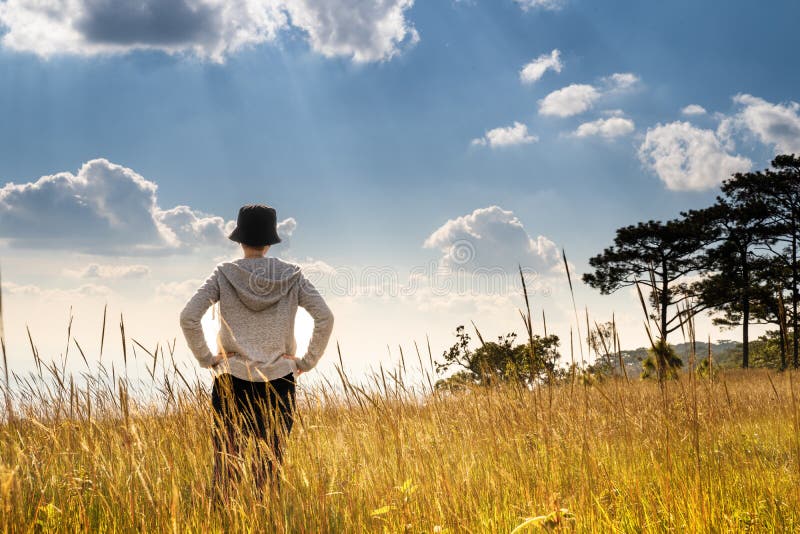 Eine Personenstellung auf dem großen Gebiet, welches die Natur unter schönem blauem Himmel genießt stockbild