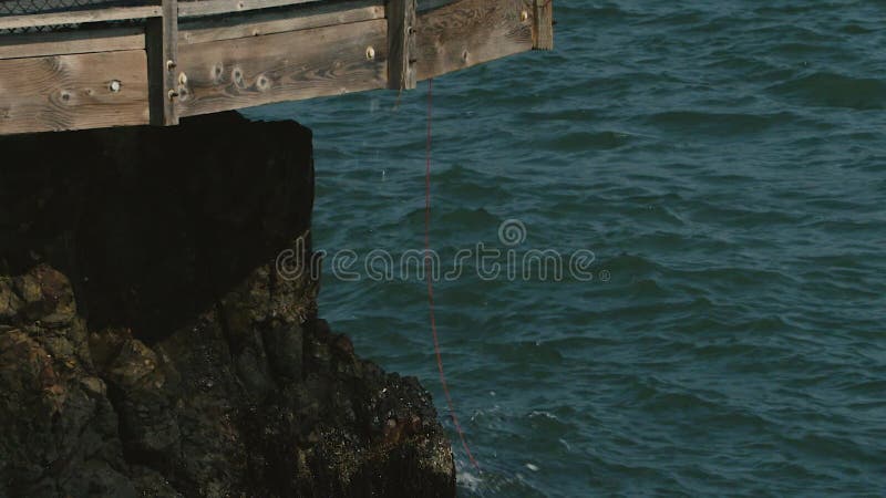 Eine rote Angelschnur baumelt von einem schwierigen Pier im tiburon Kalifornien