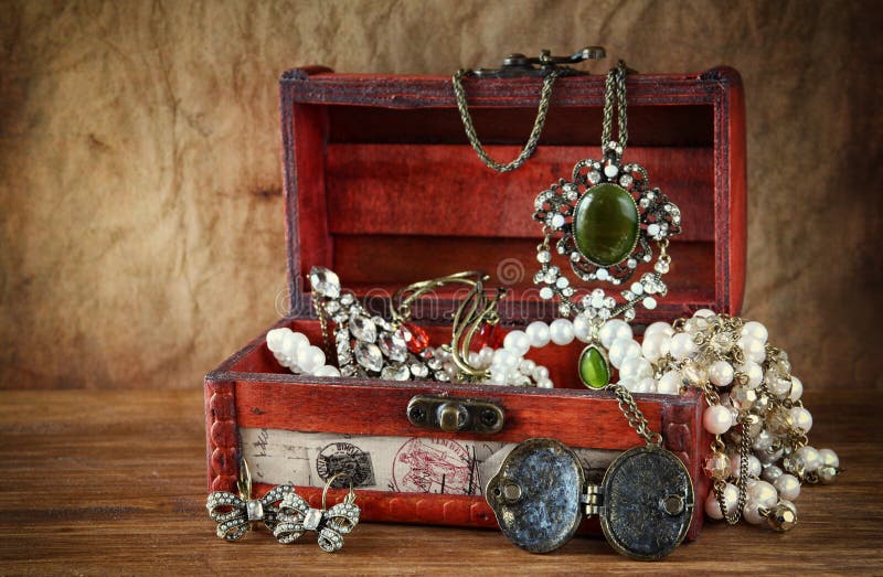 A collection of vintage jewelry in antique wooden jewelry box . A collection of vintage jewelry in antique wooden jewelry box .