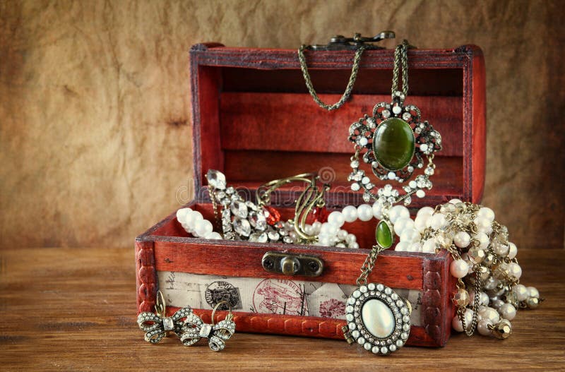 A collection of vintage jewelry in antique wooden jewelry box. A collection of vintage jewelry in antique wooden jewelry box.